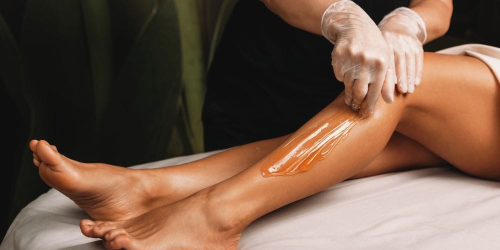 Woman getting her legs waxed.