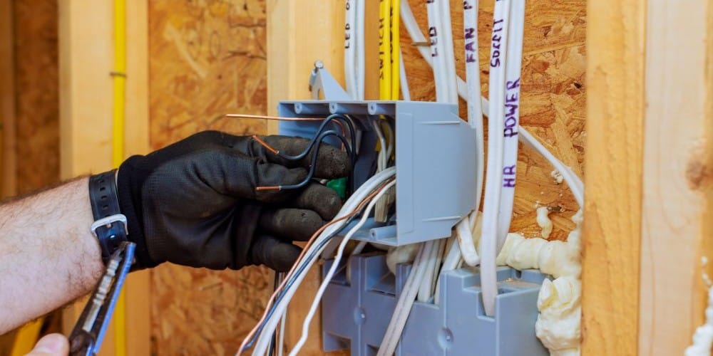 Electrician installing an electrical outlet in a new home.